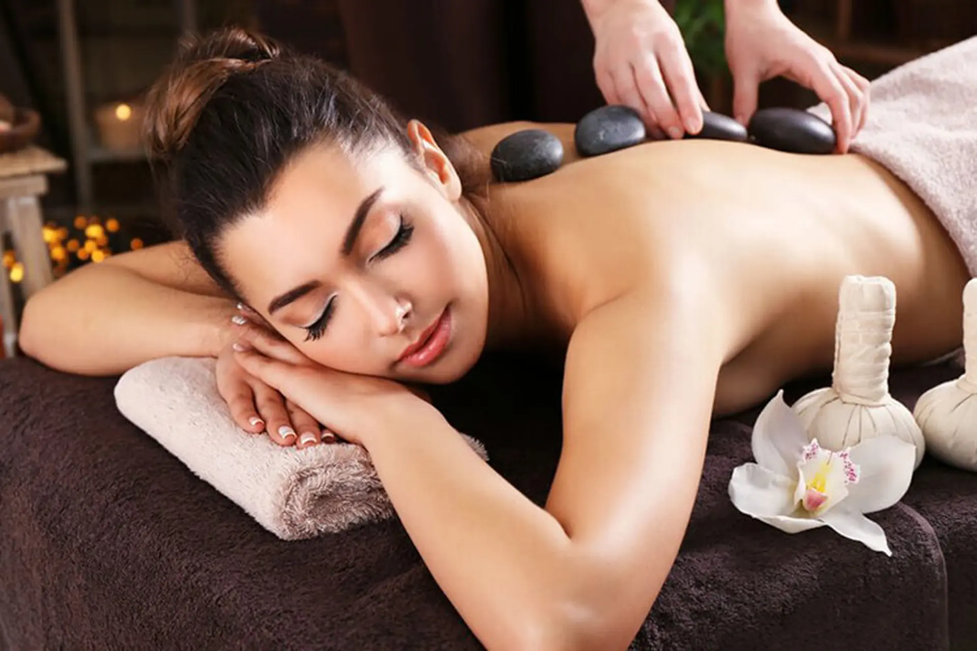 Kỹ thuật viên dùng đá nóng massage vùng vai gáy giảm căng cơ