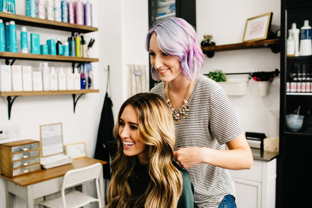 Salon tóc đẹp tại Đà Nẵng với stylist đang tạo kiểu tóc uốn sóng cho khách